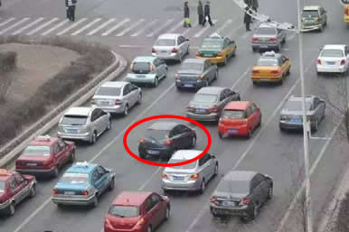 如图所示，红圈标注的深色车辆的做法是违法的。
